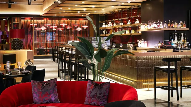 Bar mit roten Samtsofas und gedämpftem Licht – erster Besuch im Swingerclub