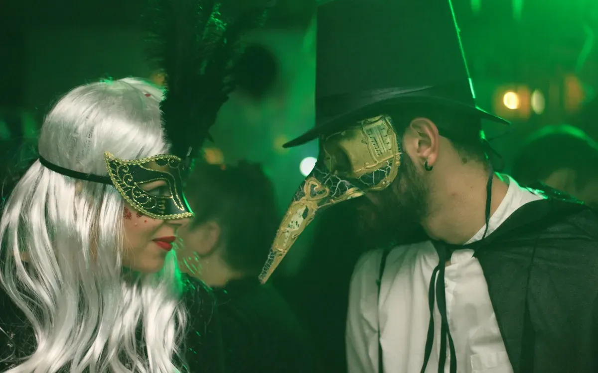 Paar mit Masken auf einer Party