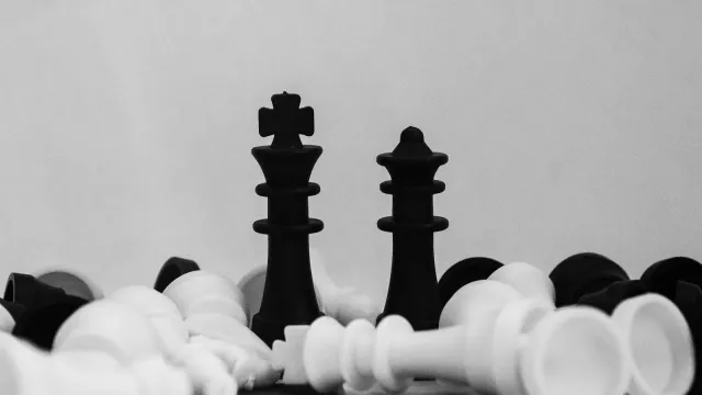 Schwarzer König und schwarze Dame zwischen umgefallenen weißen Schachfiguren – Cuckold und Hotwife erklärt