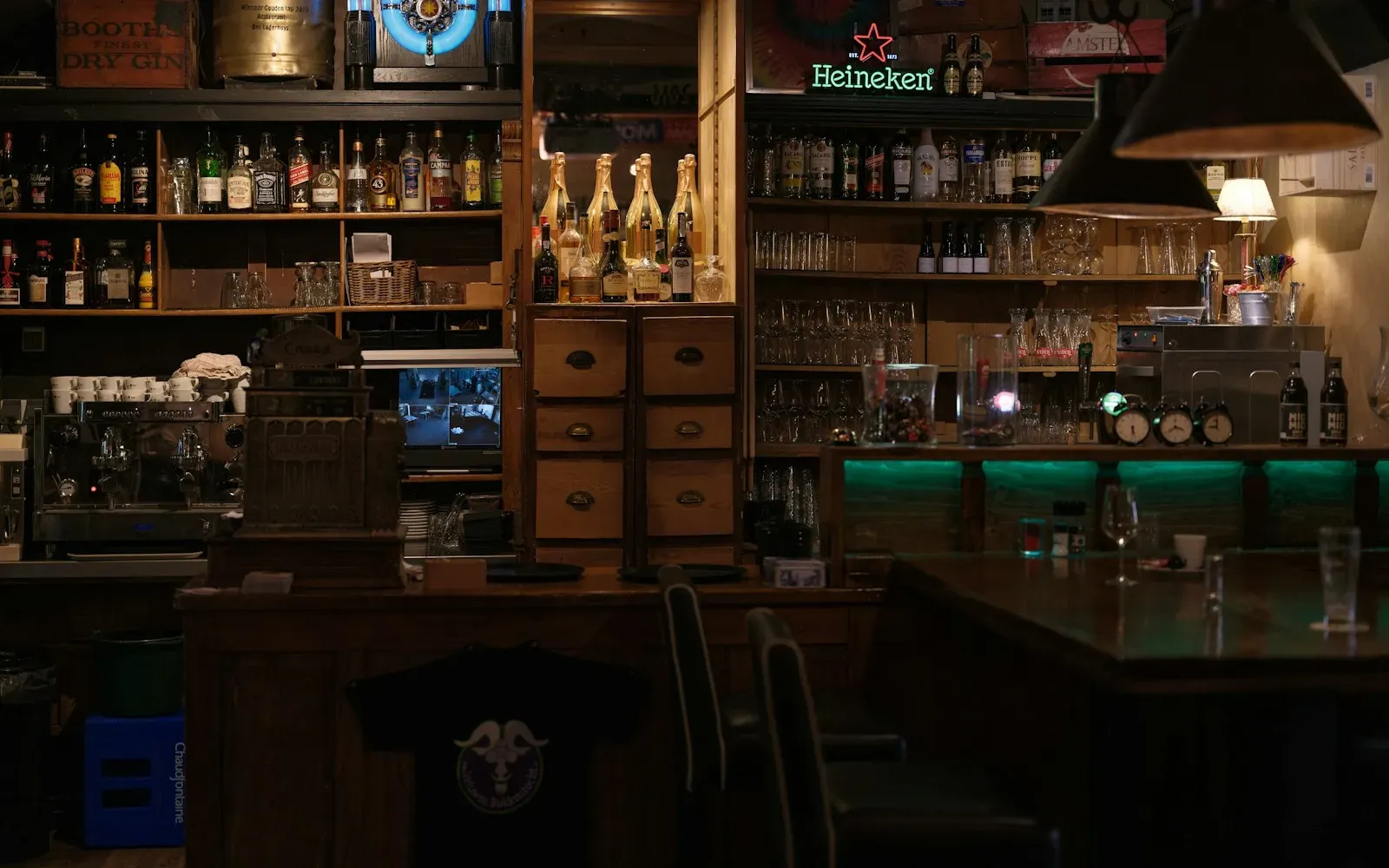Gedimmte Bar mit Flaschenregalen und grünem Licht – Swingerclub zum ersten Mal als Paar